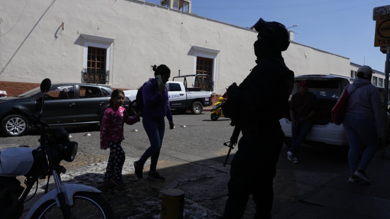 A municipal police officer stands guard in Maravatio, Michoacan state, Mexico, Tuesday, Feb. 27, 2024. Two mayoral hopefuls in this city were gunned down the previous day within hours of each other, ahead of the June 2 national elections. (Fernando Llano / AP Photo)