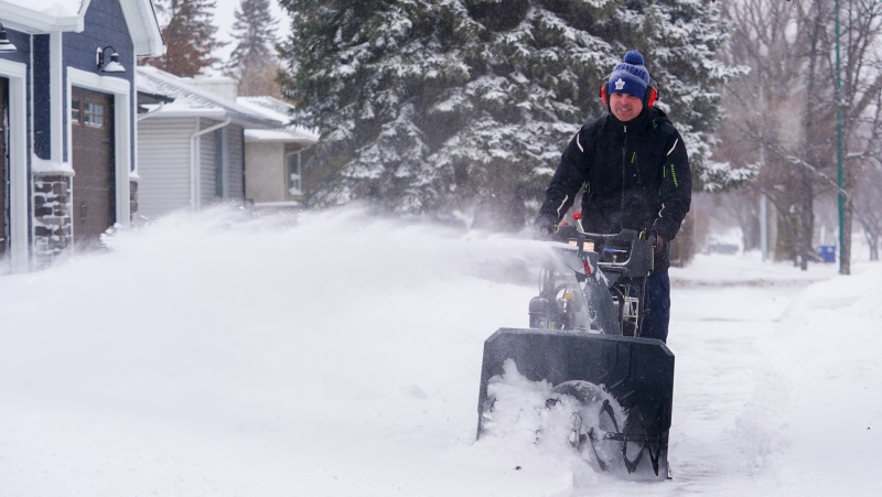 A person pushes a snowblower in Saskatoon, Sask., Monday, Feb. 26, 2024. THE CANADIAN PRESS/Heywood Yu
