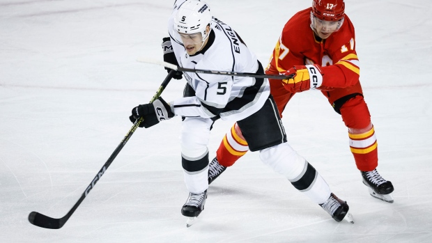 Los Angeles Kings defenceman Andreas Englund (5) is checked by Calgary Flames forward Yegor Sharangovich (17) during second period NHL hockey action in Calgary, Tuesday, Feb. 27, 2024.THE CANADIAN PRESS/Jeff McIntosh