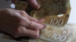 Canadian $100 bills are counted in Toronto, Feb. 2, 2016. THE CANADIAN PRESS/Graeme Roy