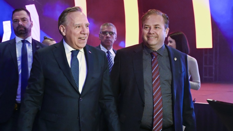 Quebec Premier Francois Legault, left, and Federation Quebecois des Municipalites president Jacques Demers walk in at the FQM annual meeting, Friday, Sept. 29, 2023 in Quebec City. (Jacques Boissinot, The Canadian Press)
