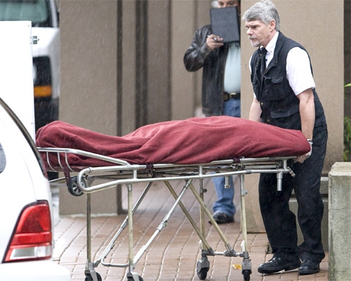 Body removal personnel load the body of one of the six people murdered in Surrey, B.C. (CP / Jonathan Hayward)