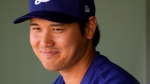 Los Angeles Dodgers designated hitter Shohei Ohtani smiles in the dugout before a spring training baseball game against the Texas Rangers, Wednesday, Feb. 28, 2024, in Surprise, Ariz. (AP Photo/Lindsey Wasson)