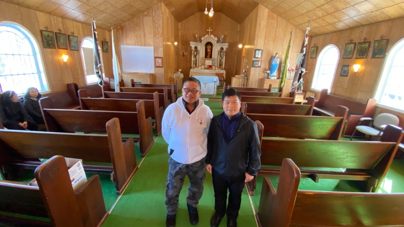 Edwin Sonsona (right) and Father Paul Nguyen pose for a photo inside Saint Isidore Roman Catholic Parish in Vita, Man. (Danton Unger/CTV News Winnipeg)
