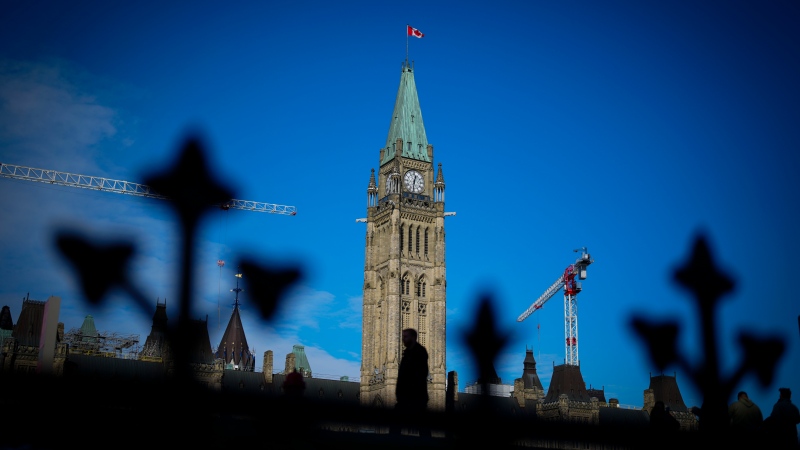 A person makes their way past the Peace Tower on Parliament Hill in Ottawa on Tuesday, Feb. 13, 2024. (Sean Kilpatrick/The Canadian Press)