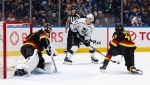 Los Angeles Kings' Trevor Moore (12) looks to shoot the puck as Vancouver Canucks goaltender Thatcher Demko (35) watches and Quinn Hughes (43) defends during the second period of an NHL hockey game in Vancouver, on Thursday, Feb. 29, 2024. THE CANADIAN PRESS/Ethan Cairns