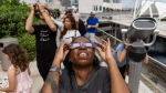 Jamila Thompson watches a partial solar eclipse at the Frost Science Museum on Saturday, Oct. 14, 2023, in downtown Miami. (Matias J. Ocner/Miami Herald via AP) 