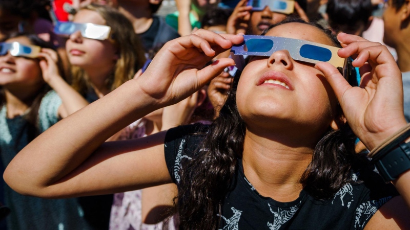 Students wear protective glasses to view a partial solar eclipse over Schiedam, Netherlands, in June 2021. (Marco de Swart / ANP / AFP / Getty Images via CNN Newsource)