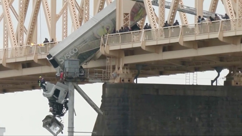 Louisville emergency crews rescue the driver of semi-truck dangling off the Clark Memorial Bridge over the Ohio River on Friday, March 1, 2024 in Louisville, Ky. (WDRB via AP)