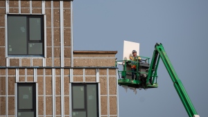 A construction worker uses an articulating boom lift to move a piece of construction equipment at the site of an affordable housing project in the Thornecliffe Park region of Ottawa, on Thursday, Sept. 28, 2023. (Spencer Colby/THE CANADIAN PRESS)