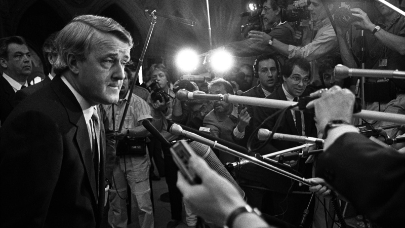 Prime Minister Brian Mulroney leans over to be able to hear a question during a scrum outside the Tory caucus room in Ottawa Wednesday, June 7, 1988. (CP PHOTO) 