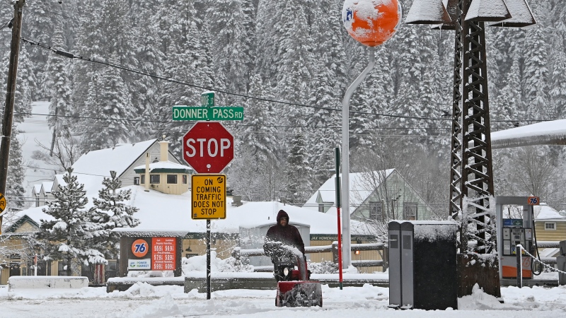 Juan Manuel plows the snow off the sidewalk in front of The Bar of American where he is employed on Friday, March 1, 2024, in downtown Truckee, Calif. The most powerful Pacific storm of the season is forecast to bring up to 10 feet of snow into the Sierra Nevada by the weekend (AP Photo/Andy Barron)