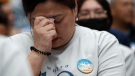 A family member of passengers on board of the missing Malaysia Airlines Flight 370 cries during the tenth annual remembrance event at a shopping mall, in Subang Jaya, on the outskirts of Kuala Lumpur, Malaysia, Sunday, March 3, 2024. Ten years ago, a Malaysia Airlines Flight 370, had disappeared March 8, 2014 while en route from Kuala Lumpur to Beijing with 239 people on board. (AP Photo/FL Wong)