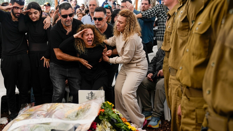 Sivan, mother of Israeli soldier, Sergeant Dolev Malca, screams as she salutes her son during his funeral in Shlomi, northern Israel, on the border with Lebanon, Sunday, March 3, 2024. Malca ,19, was killed during Israel's ground operation in the Gaza Strip, where the Israeli army has been battling Palestinian militants in the war ignited by Hamas' Oct. 7 attack into Israel. (AP Photo/Ariel Schalit)