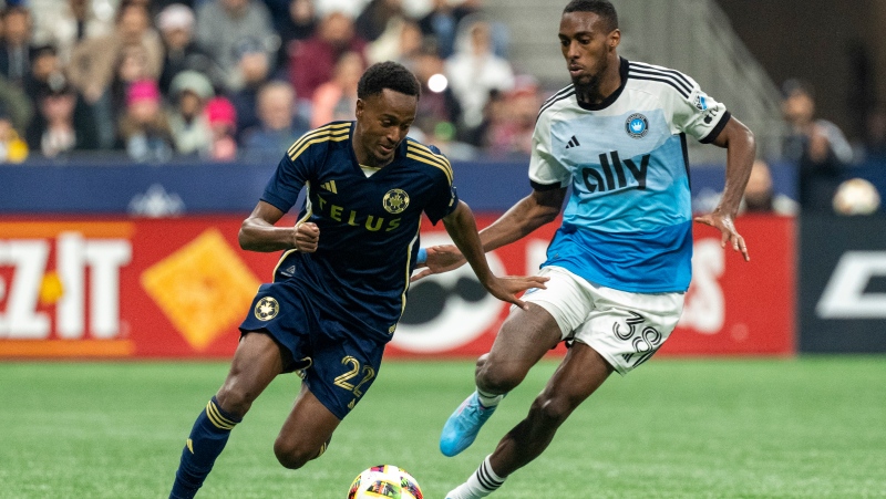 Vancouver Whitecaps' Ali Ahmed (22) and Charlotte FC's Iuri Tavares (38) vie for the ball during the second half of an MLS soccer match in Vancouver, on Saturday, Mar. 2, 2024. THE CANADIAN PRESS/Ethan Cairns