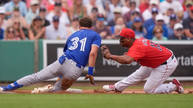 Boston Red Sox third baseman Rafael Devers tags out Toronto Blue Jays Cam Eden at third as he tries to stretch a double into a triple in the fifth inning of a spring training baseball game in Fort Myers, Fla., Sunday, March 3, 2024. (AP Photo/Gerald Herbert)