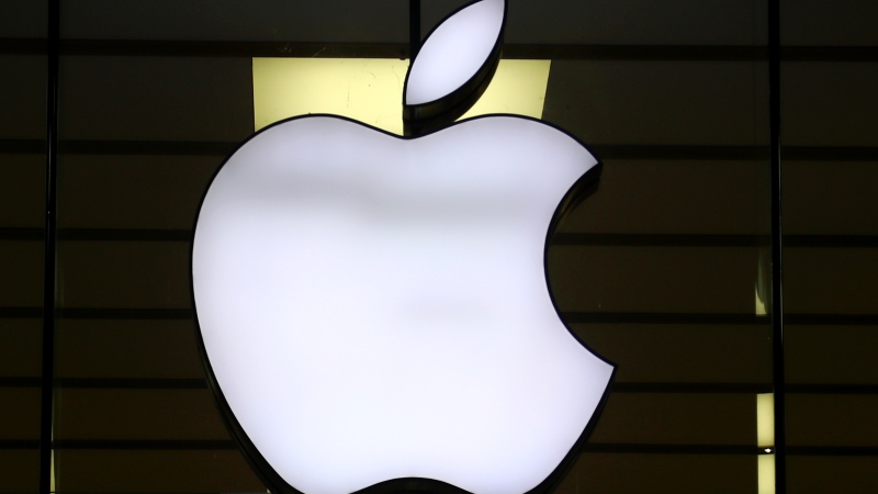 The Apple logo is illuminated at a store in the city center of Munich, Germany, Dec. 16, 2020. (AP Photo/Matthias Schrader, File)