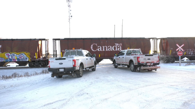 Two Canadian National Railway trucks sit in front of a parked train at Poundmaker Road and Veness Road in St. Albert after a partial derailment the morning of March 4, 2024. (Evan Klippenstein / CTV News Edmonton) 