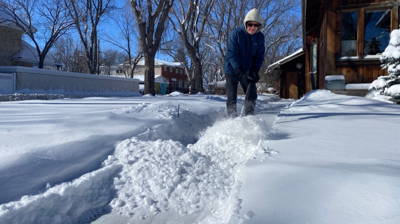 A resident of Cathedral Neighborhood shovels snow from his sidewalks on Monday March 4, 2024. (GarethDillistone/CTVNews)