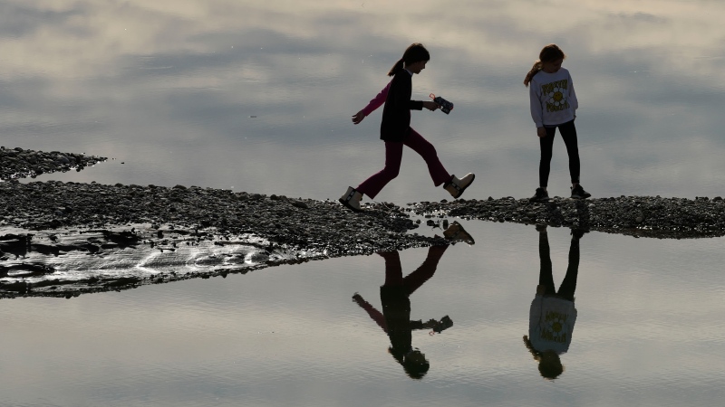 Children play during a sunny winter's day on the sandbank in the Drina river near Bijeljina, 200 kms north of Sarajevo, Bosnia, Sunday, Feb. 4, 2024. (AP Photo/Darko Vojinovic)