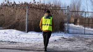 Security guards the entrance to the construction site of the new EV battery plant, Northvolt, in Saint-Basile-le-Grand, east of Montreal, Quebec, Friday, Jan. 19, 2024. The Swedish multinational announced Thursday that work had been temporarily suspended on the site in McMasterville and Saint-Basile-le-Grand “out of respect for the ongoing legal process.” (Christinne Muschi, The Canadian Press)