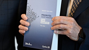 A copy of the provincial budget is shown in the hands of Quebec Premier Francois Legault Tuesday, March 12, 2024, at the premier’s office in Quebec City. THE CANADIAN PRESS/Jacques Boissinot