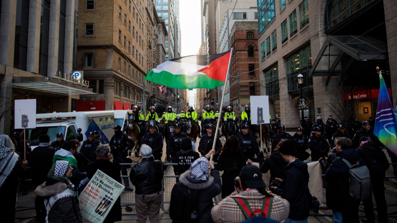 Protestors for Gaza gather outside the King Edward Hotel, in Toronto, the planned location of an event for Prime Minister Justin Trudeau, Friday, Mar. 15, 2024. THE CANADIAN PRESS/Cole Burston