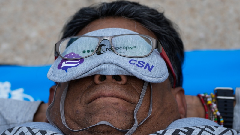 Equipped with a mat, sleeping mask and travel pillow, a man takes a nap at the base of the iconic Monument to the Revolution, during an event dubbed the “mass siesta,” commemorating World Sleep Day, in Mexico City, Friday, March 15, 2024. (AP Photo/Fernando Llano)
