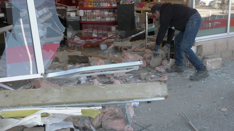 A cleanup worker sorts through the debris after a car crashed through the front of a Bulk Barn store in Windsor, Ont. on Mar. 16, 2024. (Sanjay Maru/CTV News Windsor)