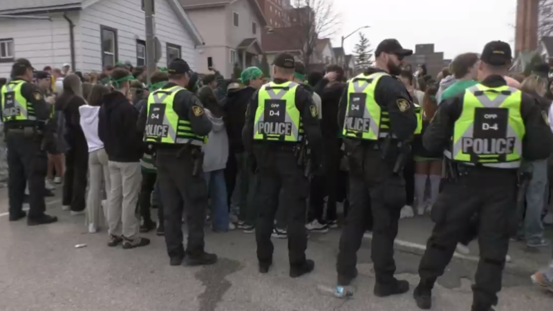 Police keep an eye on students taking part in St. Patrick's Day celebrations on Marshall Street on March 16, 2024. 