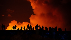 Spectators watch plumes of smoke from volcanic activity between Hagafell and Stóri-Skógfell, Iceland, on Saturday, March 16, 2024. (AP Photo/Marco di Marco)