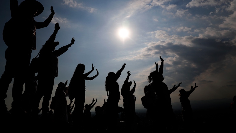 Visitors hold their hands out to receive the sun's energy as they celebrate the Spring equinox atop the Pyramid of the Sun in Teotihuacan, Mexico, Thursday, March 21, 2019.  (AP Photo/Marco Ugarte, File)