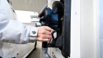 A woman pumps gas at a gas station in Mississauga, Ont., on February 13, 2024. THE CANADIAN PRESS/Christopher Katsarov