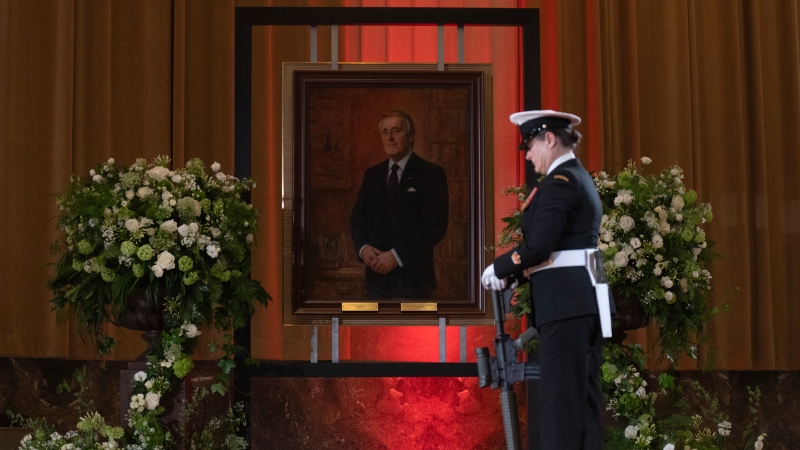 The Honour Guard practises their positions in front of a portrait of former prime minster Brian Mulroney before the arrival of his casket, Tuesday, March 19, 2024 in Ottawa. THE CANADIAN PRESS/Adrian Wyld