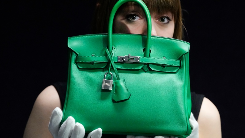 A Bonhams employee displays a Hermes: a Bambou Swift Leather Birkin 25 bag, at the auction rooms in London, Monday, Feb. 26, 2024. (AP Photo/Kirsty Wigglesworth)
