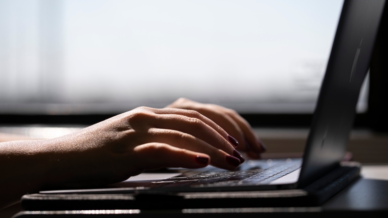 A person types on a laptop. (Source: THE CANADIAN PRESS/AP-Jenny Kane)