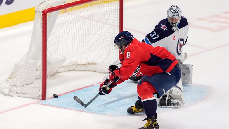 Washington Capitals left wing Alex Ovechkin (8) scores past Winnipeg Jets goaltender Connor Hellebuyck (37) in the third period of an NHL hockey game, Sunday, March 24, 2024, in Washington. (AP Photo/Mark Schiefelbein)