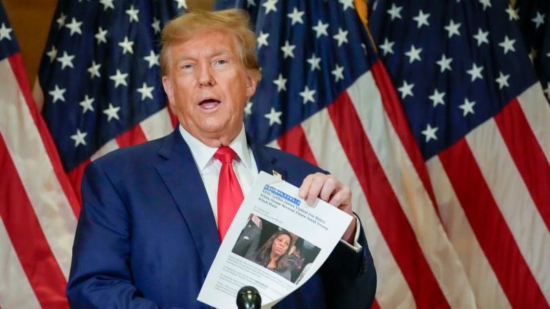 Former President Donald Trump holds up a copy of a story featuring New York Attorney General Letitia James while speaking during a news conference, Jan. 11, 2024, in New York. (AP Photo/Mary Altaffer, File)