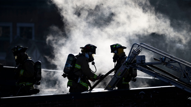 Smoke billows from the roof of a building as firefighters work at the scene of a fire in a commercial building in Ottawa's Glebe neighbourhood, on Sunday, March 24, 2024. (Justin Tang/THE CANADIAN PRESS)