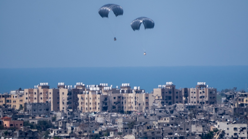 Parachutes airdrops humanitarian aid over the northern Gaza Strip, as seen from southern Israel, Tuesday, March 26, 2024. (AP Photo/Ariel Schalit)