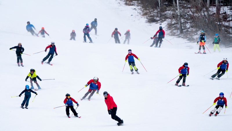 Prime Minister Justin Trudeau, in red, enjoys the slopes with youth from the NorWesters Alpine Club and Port Arthur Ski Club at Loch Lomond Ski Hill in Thunder Bay, Ont., on Thursday, February 29, 2024. (THE CANADIAN PRESS/David Jackson)