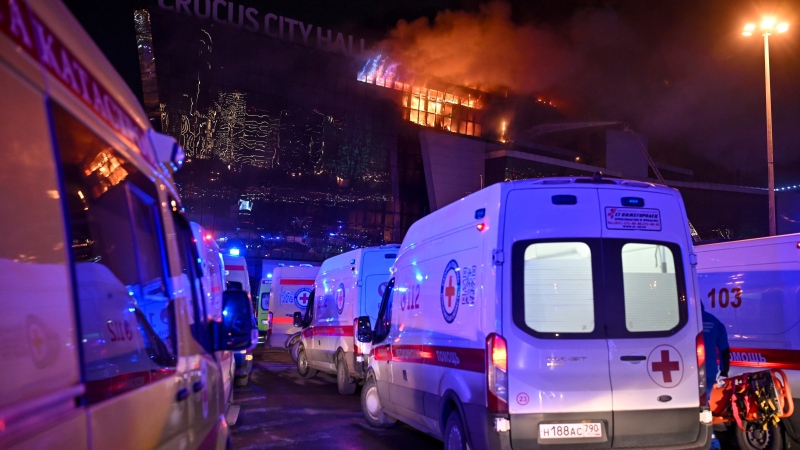 Ambulances park near a burning building of the Crocus City Hall on the western edge of Moscow, Russia, Friday, March 22, 2024. (AP Photo/Dmitry Serebryakov)