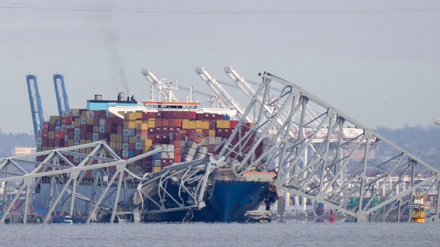 A container ship rests against wreckage of the Francis Scott Key Bridge on Tuesday, March 26, 2024. (AP Photo/Mark Schiefelbein)