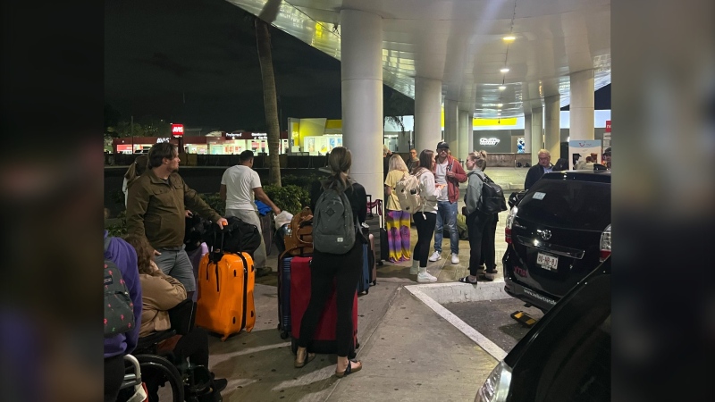 Vacationers wait outside of the Cancun airport after their flight was cancelled on Saturday night. (Courtesy: Joal Ebach)