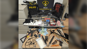 Police display weapons, drugs and cash allegedly seized during a search at a Front Street address in Orillia, Ont., on Wed., March 27, 2024. (Source: OPP)