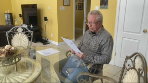 Austin Lonsdale reviews a letter from his insurance provider in his Ottawa home. (Natalie van Rooy/CTV News Ottawa)