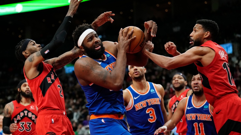 New York Knicks centre Mitchell Robinson (centre) is fouled by Toronto Raptors forward Garrett Temple (right) as Raptors forward Jalen McDaniels (2) defends during second half NBA basketball action in Toronto on Wednesday, March 27, 2024. THE CANADIAN PRESS/Frank Gunn