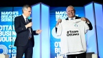 Premier of Ontario Doug Ford receives a customized sports jersey from Ottawa Mayor Mark Sutcliffe at the Ottawa Board of Trade's Mayor's Breakfast Series, in Ottawa, on Thursday, March 28, 2024. (Justin Tang/THE CANADIAN PRESS)
