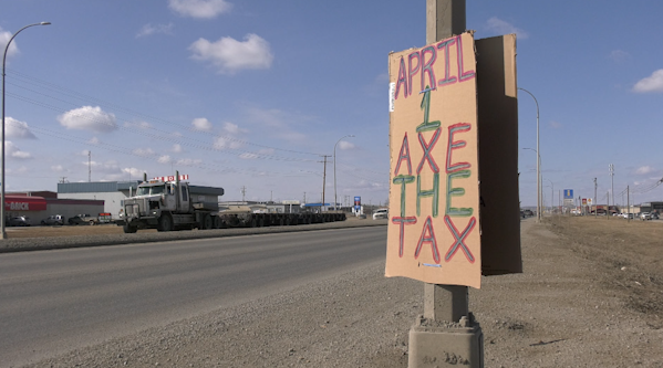 A sign advertising an April 1st 'Axe the Tax' rally hangs on a lamp post along Highway 97 in Fort St. John. 