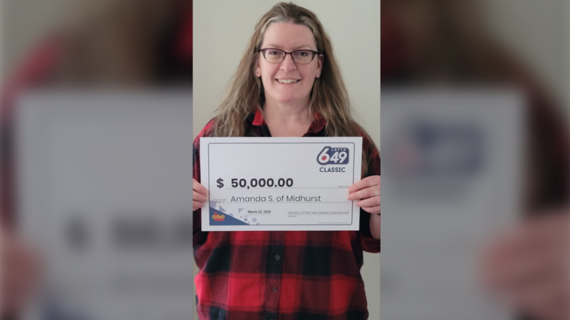 Amanda Storey from Midhurst Ont, holds her winning ticket from the Lotto 6/49 Super Draw held on Feb., 14, 2024. (OLG)